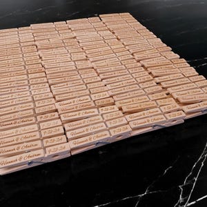 May include: A large quantity of wooden clothespins with the text "Hannah & Andrew 7-21-24" engraved on each one.