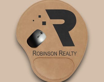 May include: A brown leather mouse pad with a black letter "R" and the text "Robinson Realty".