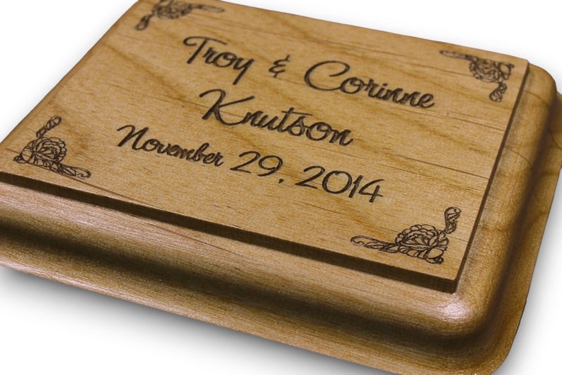 May include: A wooden box with an engraved inscription that reads "Troy & Corrine Knutson November 29, 2014". The box has a decorative design in the corners.