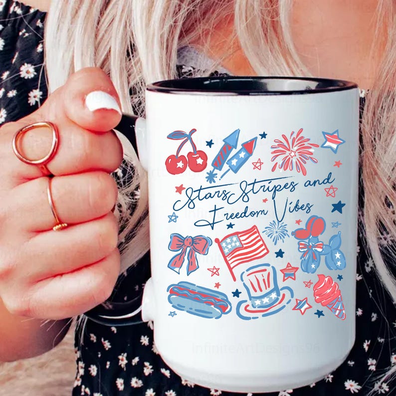 May include: White ceramic mug with a black rim and handle, featuring a patriotic design. The mug is decorated with red, white, and blue illustrations of fireworks, cherries, an American flag, and the text "Stars Stripes and Freedom Vibes."