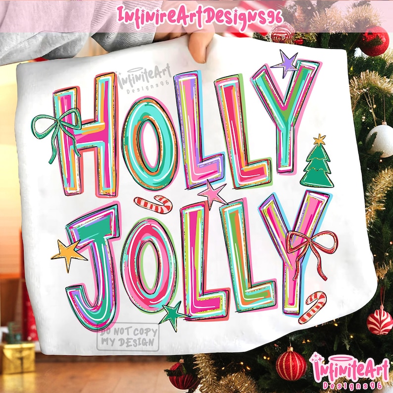 May include: A white t-shirt featuring the colorful text HOLLY JOLLY in bright pink, teal, and yellow outlines. The design includes a green Christmas tree, two red and white candy canes, a green bow, a red bow, and several small stars.
