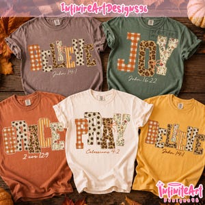 May include: Five short-sleeved crewneck t-shirts in mauve, olive green, rust orange, cream, and mustard yellow. Each shirt features large block letters spelling BELIEVE, JOY, GRACE, or PRAY, decorated with plaid, leopard, and floral patterns.