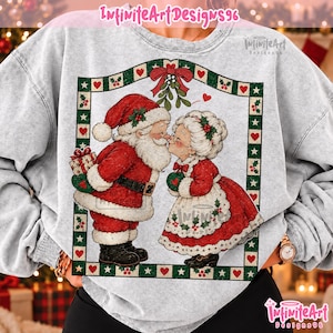 May include: A light gray acid-wash sweatshirt featuring a graphic of Santa Claus and Mrs. Claus kissing under mistletoe. The design is framed by a green border with red hearts and holly. The text InfiniteArtDesigns96 appears at the top.