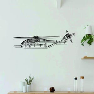 May include: A black line drawing of a helicopter on a white wall. The helicopter is mounted on the wall and has a shadow underneath it. The helicopter is in the center of the image. There is a wooden shelf below the helicopter with a few decorative items on it.