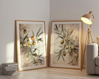 May include: Two framed watercolor prints of olive branches with green and orange olives. The artwork has a neutral color palette with a light brown wooden frame. The prints are leaning against a white wall.