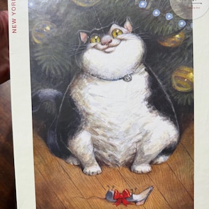 Puede incluir: Un rompecabezas de 1000 piezas con un gato de dibujos animados con una sonrisa traviesa, sobre un fondo de árbol de Navidad. La caja dice "Go on, open it!" y "New York Puzzle Company".