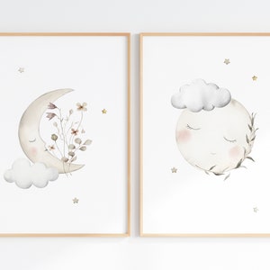 Puede incluir: Dos impresiones enmarcadas con ilustraciones de acuarela de lunas con caras dormidas. Una luna es una media luna con flores y una nube. La otra luna est&aacute; llena con una nube y hojas. Ambas tienen estrellas doradas.