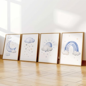 May include: Four framed watercolor prints with a blue and white color scheme. The prints feature a crescent moon, a cloud with stars, a sun and cloud, and a rainbow. Each print is framed in a light wood frame.