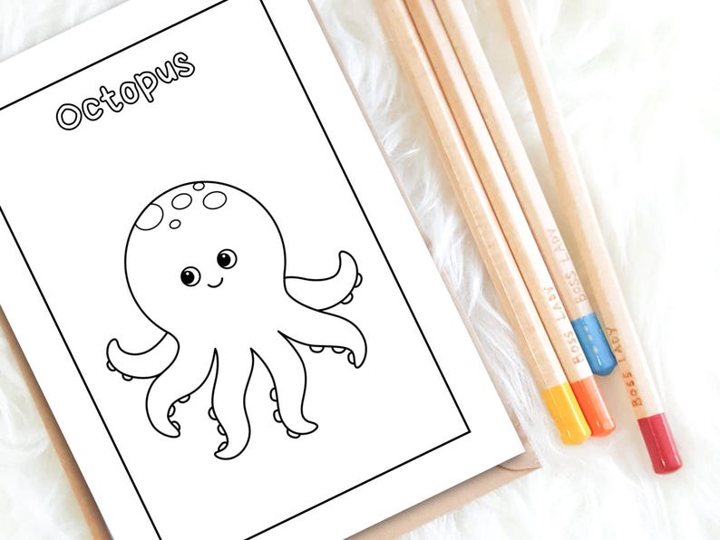 Op de afbeelding: Een kleurplaat met het woord "Octopus" boven een cartoon illustratie van een octopus. De octopus lacht en heeft acht tentakels. Vier kleurpotloden met gele, oranje, blauwe en rode punten liggen naast het boek.