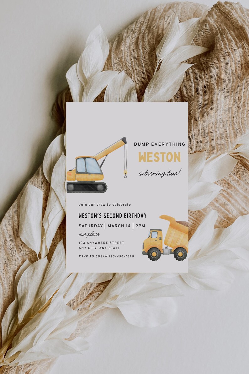 May include: A rectangular birthday invitation card featuring a yellow crane and a yellow dump truck illustration. The text reads: DUMP EVERYTHING WESTON is turning two! Join our crew to celebrate WESTON'S SECOND BIRTHDAY SATURDAY MARCH 14 2PM our place.