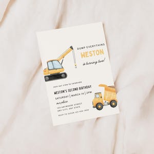 May include: A birthday invitation with a watercolor illustration of construction vehicles. The text reads "Dump Everything, Weston is turning two!" and includes party details. The invitation features a yellow excavator and a dump truck.