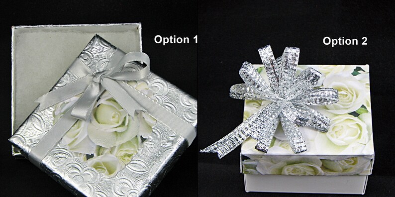 May include: Two gift boxes with different ribbon styles. The box on the left has a silver ribbon with a bow and a white rose pattern. The box on the right has a silver mesh ribbon with a bow and a white rose pattern.