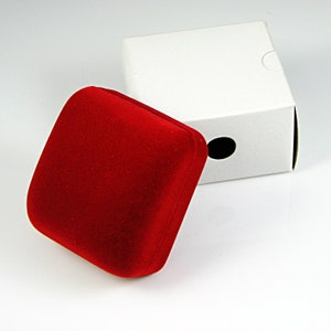 May include: A red velvet jewelry box with a white cardboard outer box. The outer box has a round hole in the top.