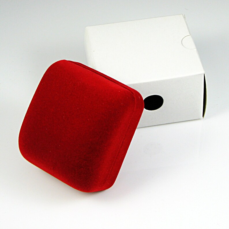 May include: A red velvet jewelry box with a white cardboard outer box. The outer box has a round hole in the top.