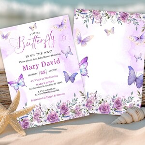 May include: Baby shower invitations with a watercolor design. The invitations feature purple butterflies and floral accents. The text reads "A Little Butterfly Is On The Way!" with event details. A starfish and seashell are in the foreground.