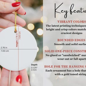 K&ouml;nnte beinhalten: Ein wei&szlig;er, runder Ornament mit einem goldenen Faden, gehalten von einer Person. Das Ornament ist 7,00 cm breit und 7,00 cm hoch, mit einer Tiefe von 3 mm. Text auf dem Bild hebt die wichtigsten Merkmale hervor.