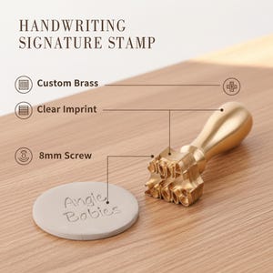 Op de afbeelding: Een Handgeschreven Handtekening Stempel met een aangepast messing ontwerp. De stempel heeft een 8 mm schroef en cre&euml;ert een duidelijke afdruk. De stempel wordt getoond met een ronde, lichtgrijze afdruk met de tekst "Angie Babies".
