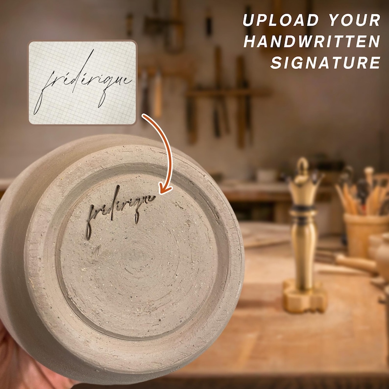 Op de afbeelding: Een beige keramische vaas met een handgeschreven handtekening, "friderique", aan de onderkant. De afbeelding bevat de tekst "UPLOAD YOUR HANDWRITTEN SIGNATURE."