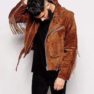 Könnte beinhalten: Eine braune Wildlederjacke mit Fransenbesatz. Die Jacke hat einen Reißverschluss und mehrere Taschen.