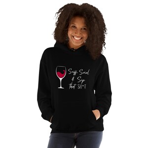 Puede incluir: Sudadera con capucha negra con un gráfico blanco de una copa de vino y el texto "Sniff, Swirl & Sip that SH*T"