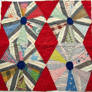 May include: A handmade quilt featuring four hexagon-shaped designs with a central blue circle and radiating stripes in various colors and patterns. The hexagons are set against a red background, creating a striking contrast. The quilt is likely made of fabric scraps.