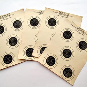 May include: Several vintage Croft's shooting targets. Each target sheet is off-white with six black bullseye targets. The text "CROFT'S" and other text is printed at the top of each sheet.