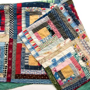 May include: A patchwork quilt constructed from various fabric scraps in a log cabin pattern. The quilt features a multitude of colors including red, blue, yellow, pink, and white, with diverse patterns such as stripes, polka dots, and florals.