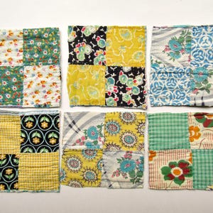 May include: Six square fabric coasters arranged in two rows of three. Each coaster features a four-patch quilt design made from various cotton fabrics with floral, plaid, and geometric patterns in yellow, green, blue, black, and white colors.
