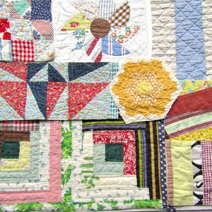 May include: A collection of assorted fabric quilt blocks featuring various patterns and colors, including red, blue, yellow, and green. The pieces display diverse geometric designs, such as log cabin, pinwheel, and hexagonal shapes, all stitched with visible quilting lines.