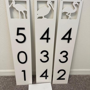 Puede incluir: Tres letreros rectangulares blancos con n&uacute;meros negros y siluetas de p&aacute;jaros recortadas. Los letreros dicen 501, 434 y 432.