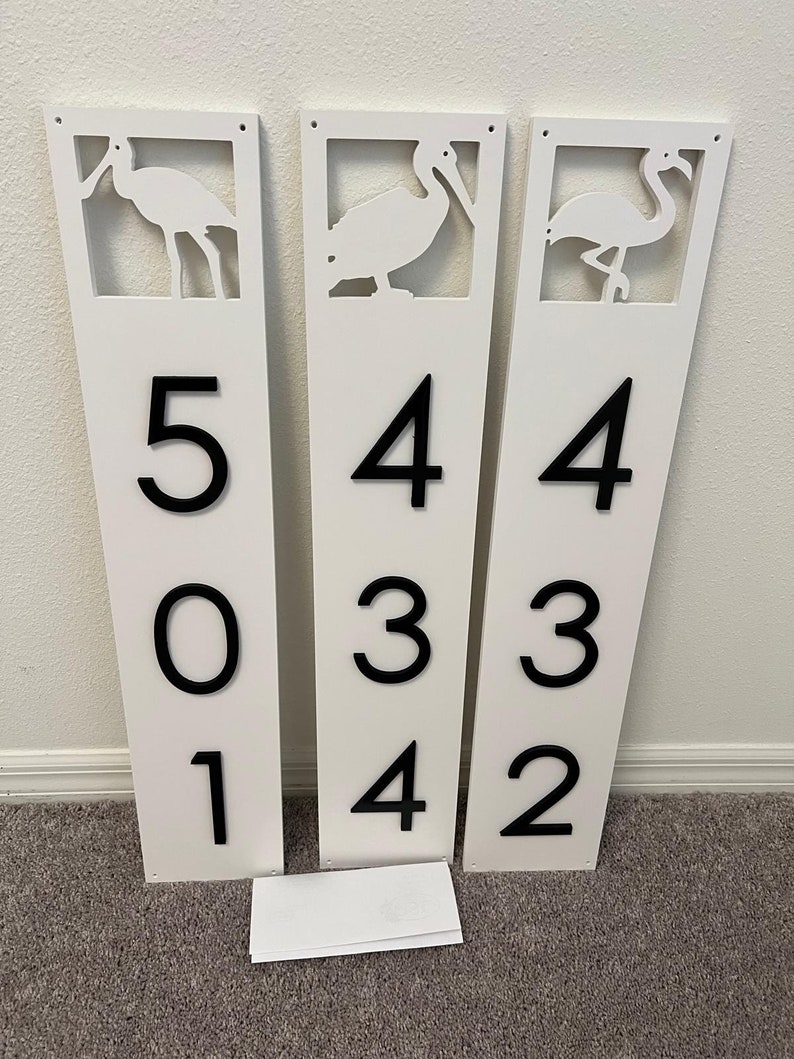 Puede incluir: Tres letreros rectangulares blancos con n&uacute;meros negros y siluetas de p&aacute;jaros recortadas. Los letreros dicen 501, 434 y 432.