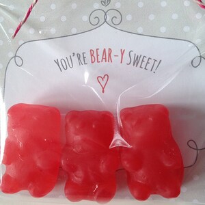 May include: A clear plastic bag filled with three red gummy bears. The bag has a white card with the text "You're Bear-Y Sweet!" and a red heart.