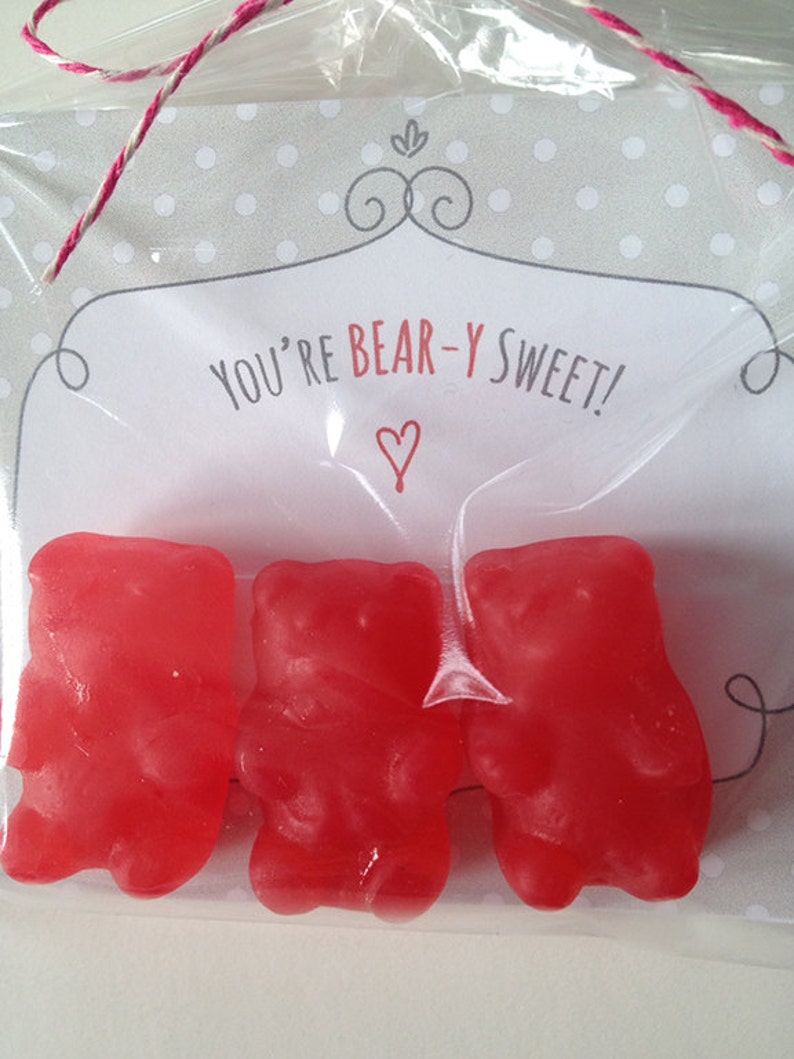 May include: A clear plastic bag filled with three red gummy bears. The bag has a white card with the text "You're Bear-Y Sweet!" and a red heart.
