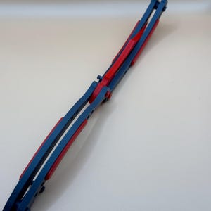 May include: A blue and red butterfly knife with a folding blade. The knife is closed and has a red handle.