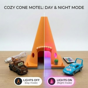 Può includere: Lampada Cozy Cone Motel arancione con modalità giorno e notte. La lampada ha la forma di un cono stradale e ha una piccola tenda da sole sopra l'ingresso. Include macchinine giocattolo e un telecomando. Il testo recita "COZY CONE MOTEL: DAY & NIGHT MODE".