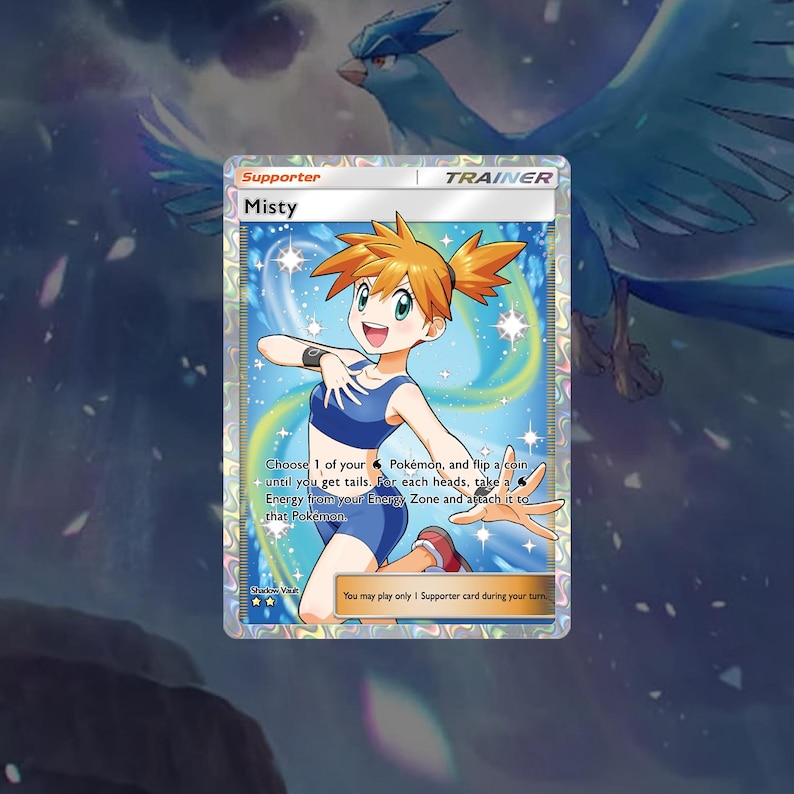 May include: A Pokemon trading card featuring Misty, a female character with orange hair, wearing a blue and white swimsuit. The card is a Trainer card and has the text "Misty" and "Choose 1 of your Pokemon, and flip a coin until you get tails. For each heads, take a Energy from your Energy Zone and attach it to that Pokemon."