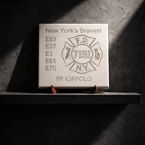 May include: A white ceramic mug with a black handle and the text "But First, Coffee" in a black, handwritten-style font. The mug is on a white surface.