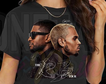 May include: Black crop top featuring a graphic of two men's faces in profile, one wearing sunglasses. The text "The RB Tour" is written in a stylized font. A gold chain necklace is visible.