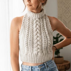 May include: A white ceramic mug with a black handle and the text "But First, Coffee" in a black, handwritten-style font. The mug is on a white surface.