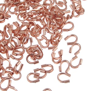 May include: A collection of small, copper-colored crimp end findings, also known as crimp end connectors, for jewelry making. The findings are U-shaped with a flattened end, designed to secure cords or chains. The image shows a close-up view of the findings.