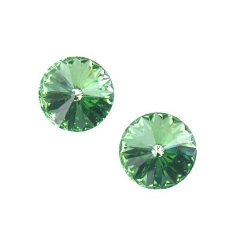 Puede incluir: Dos cristales redondos de color verde con un dise&ntilde;o facetado.