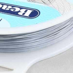 May include: A spool of silver-colored fishing line with the word "Berkley" printed on the label.