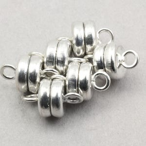 May include: Silver magnetic clasp for jewelry making. The clasp is made of multiple linked silver rings with a loop on each end.
