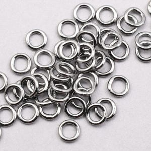 May include: A pile of silver jump rings, a type of metal ring used in jewellery making.