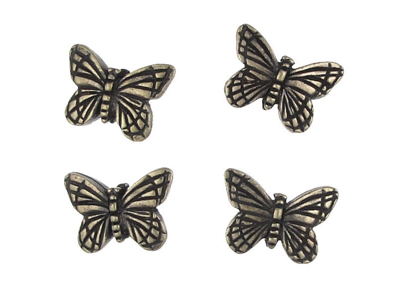 May include: Four antique gold-toned metal butterfly embellishments. Each butterfly has a detailed design with intricate wings.