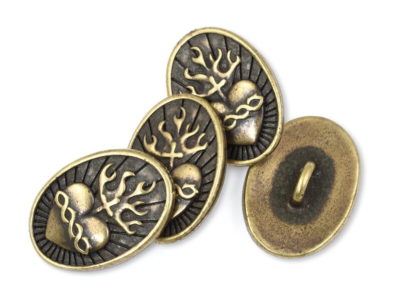 May include: Four oval-shaped brass buttons with a design of a heart with flames and a cross. The buttons have a dark brown finish and a shiny gold heart. One button has a loop on the back for sewing.