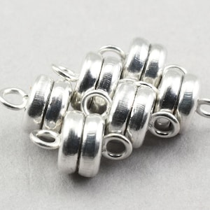 May include: Silver magnetic clasps for jewelry making. The clasps are round and have a smooth, polished finish. They are designed to be used with necklaces, bracelets, and other jewelry pieces.