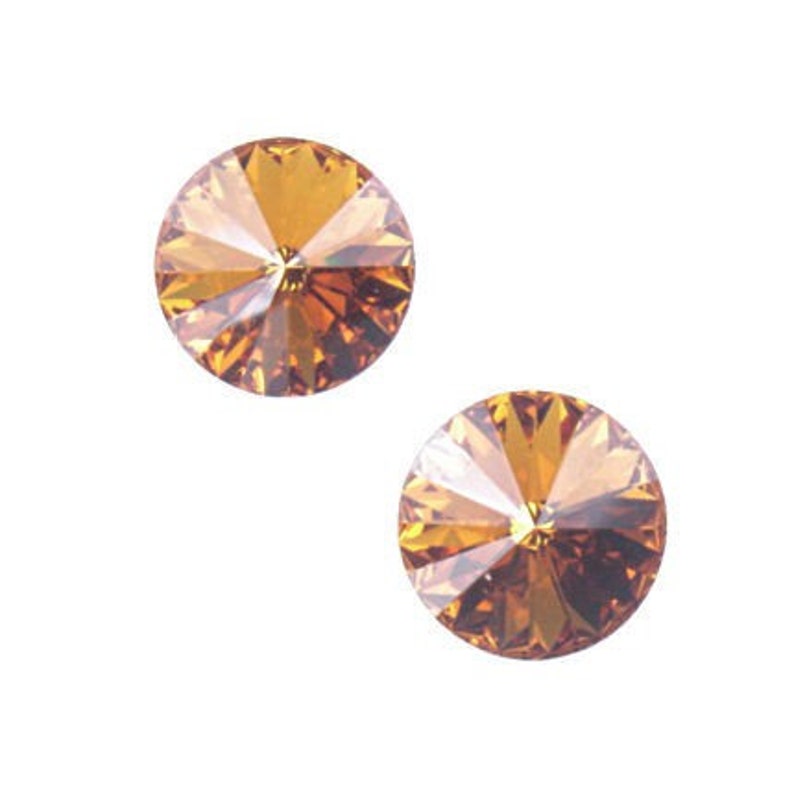 May include: Two round, faceted, amber-colored rhinestones with a starburst pattern.