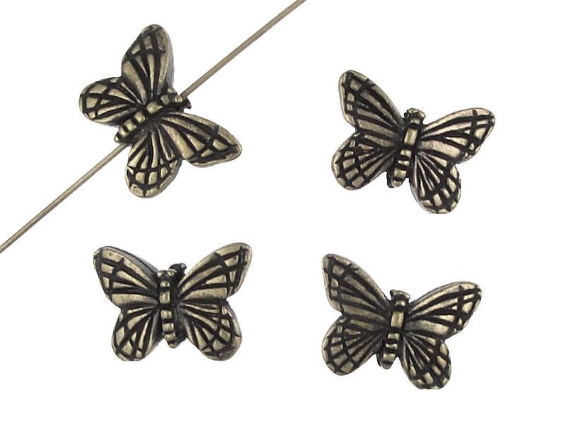 May include: Four antique silver butterfly beads. The beads are detailed with a textured design and are perfect for jewelry making.