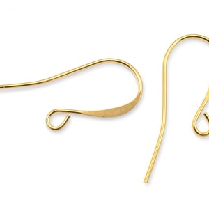 Puede incluir: Dos ganchos para pendientes de color dorado. Los ganchos son de metal y tienen un dise&ntilde;o liso y ligeramente curvado.